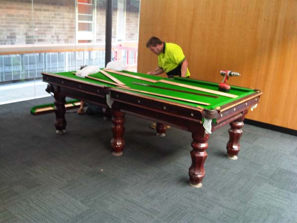 Billiard table removalists reassembling a 8 foot pool table
